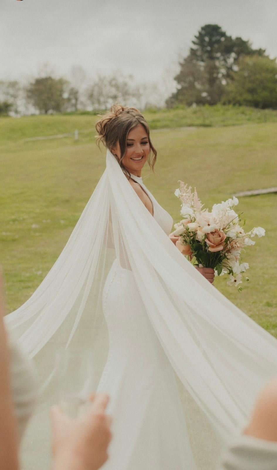 Bride with flowing veil in a coastal countryside setting